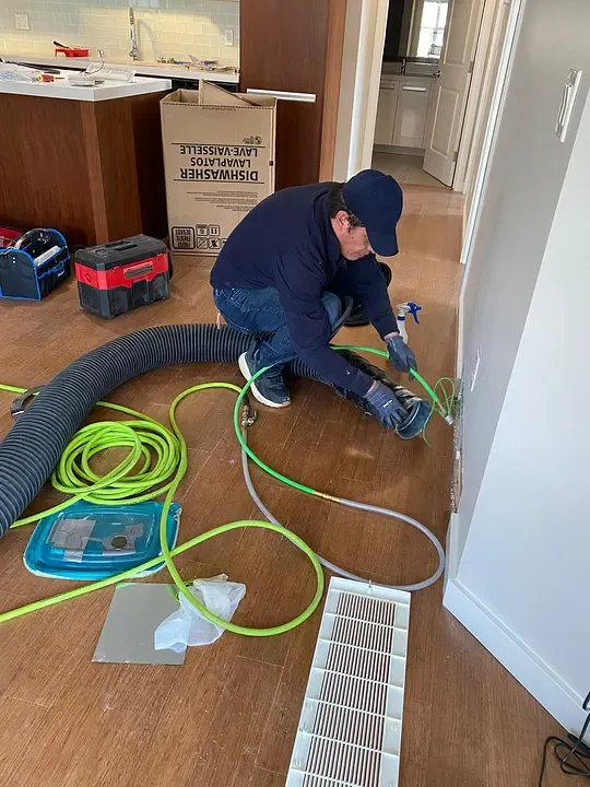 GoFlow technician carefully cleaning a floor duct in a Saskatoon home