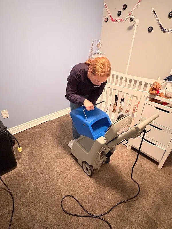Rachel using a carpet-cleaning machine in a nursery
